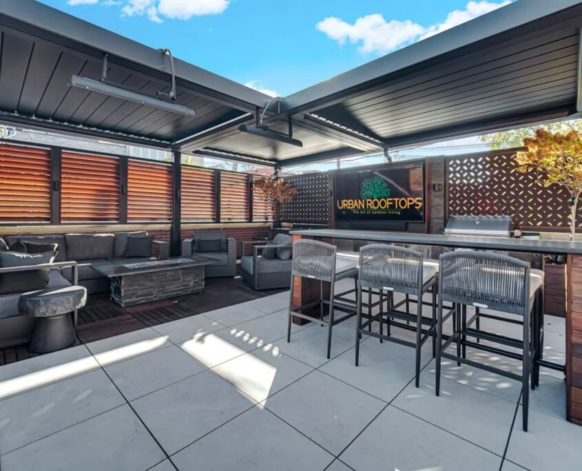 Pergola-covered garage rooftop with bar, kitchen, and lounge